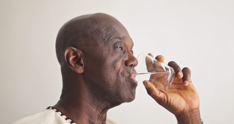 Déshydratation-des-seniors-en-climat-tropical-prévention-photo-montrant- homme-noir-mature-qui-boit-de-l-eau